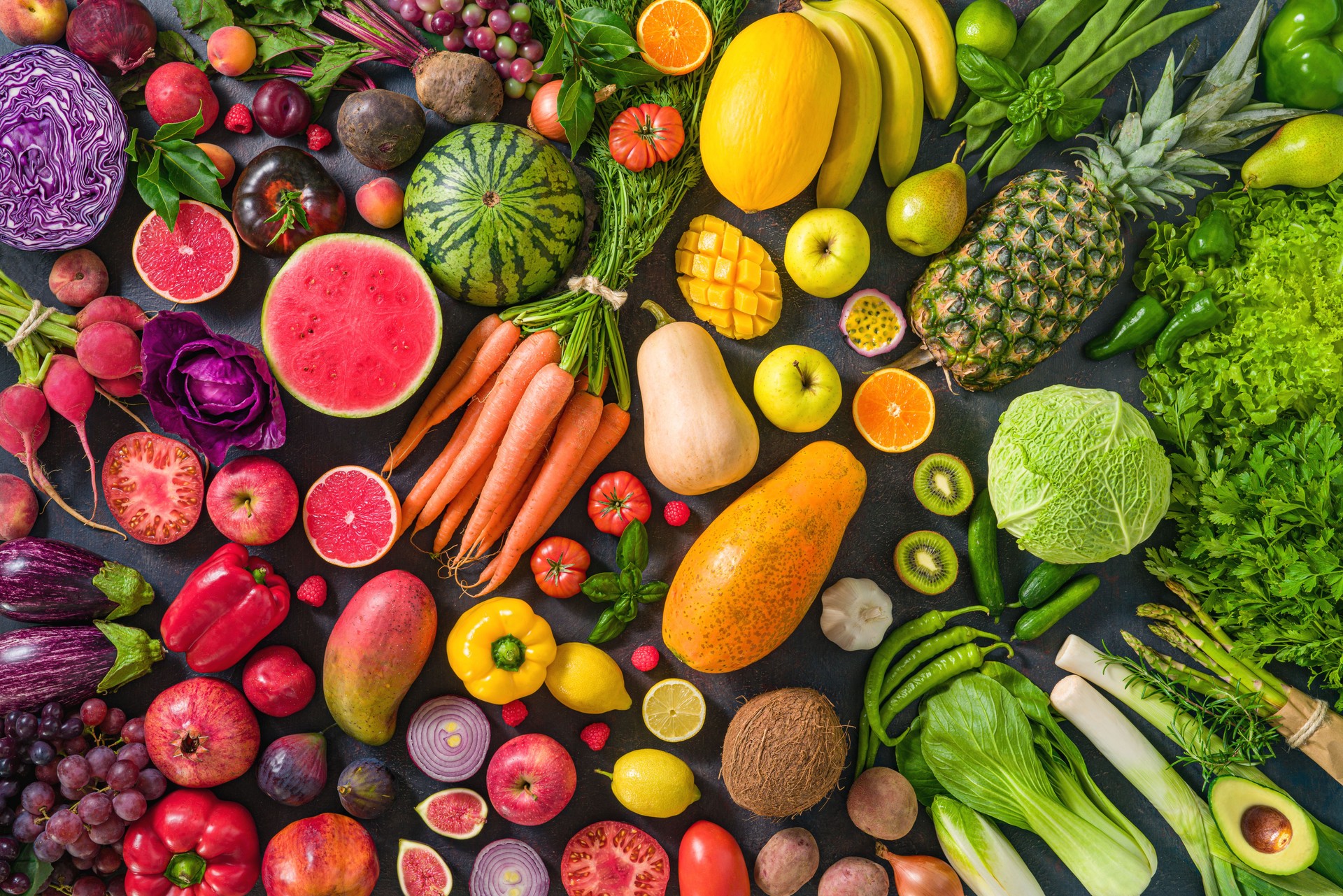 Colorful raw fruits and vegetables varied vegan food, vivid rainbow arrangement