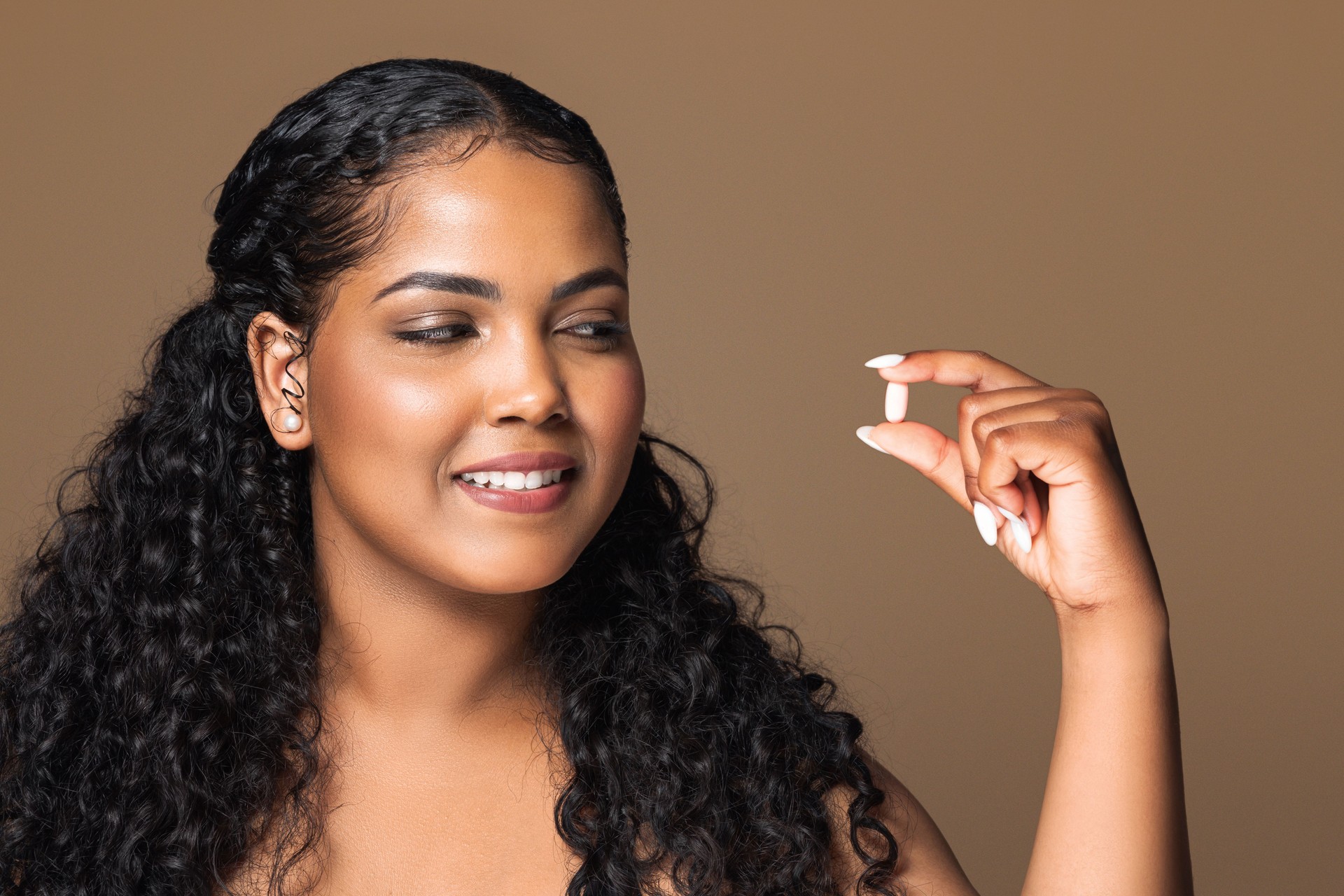 Beauty supplements. Happy latin chubby woman taking vitamin pill capsule, having medicine for healthy skin and hair